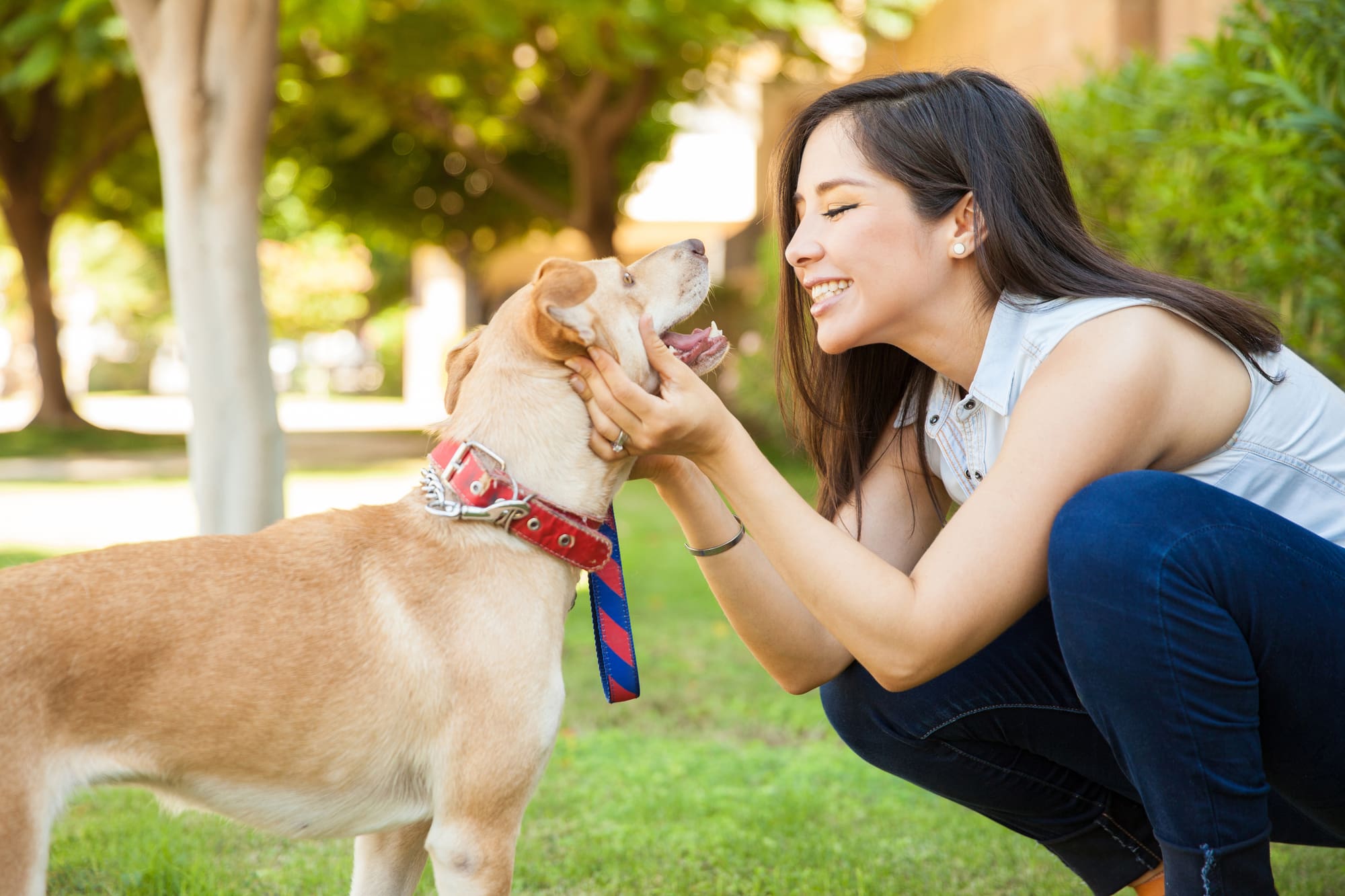 Pretty woman about to kiss her dog